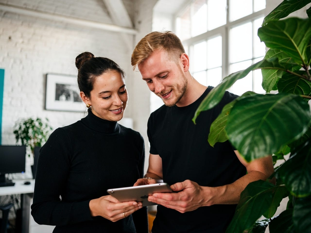 Zwei Teammitglieder schauen gemeinsam auf ein Tablet
