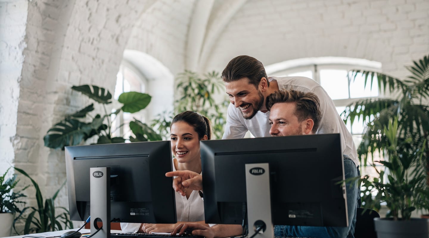 Das Team von eyvi Digital arbeitet gemeinsam an einem Schreibtisch